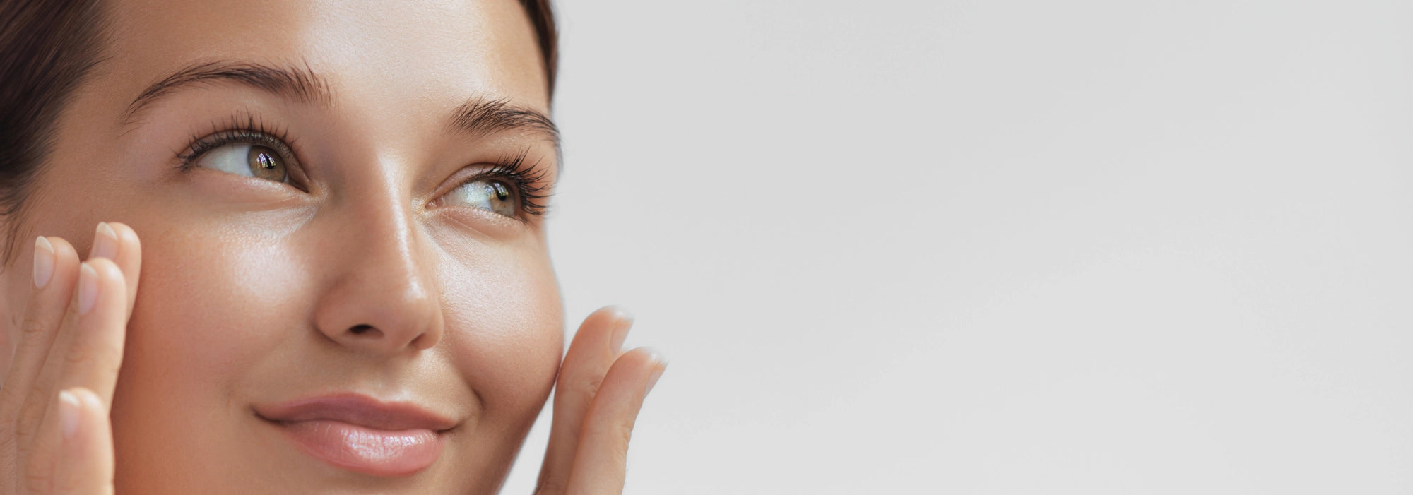 Mujer sonriendo al aplicarse skin care facial recomendado por nuestros beauty advisors