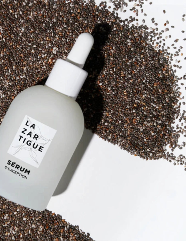 Sérum D’Exception sobre semillas naturales, resaltando su fórmula vegana sin siliconas ni aceites minerales